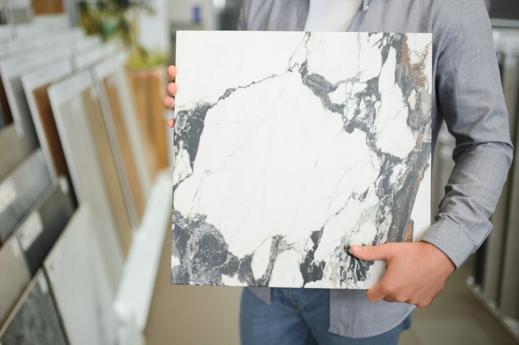 Male architect or interior designer choosing ceramic texture sample from swatch board in design studio